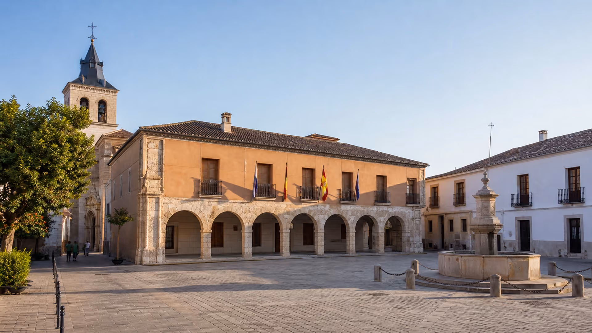 Recreación editorial de la plaza mayor de San Clemente, con el ayuntamiento porticado, la torre de la iglesia y una fuente de piedra
