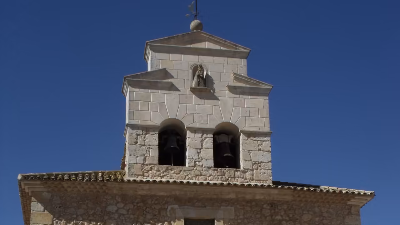 Fachada de piedra y torre de la iglesia parroquial de Casas de los Pinos, Cuenca.