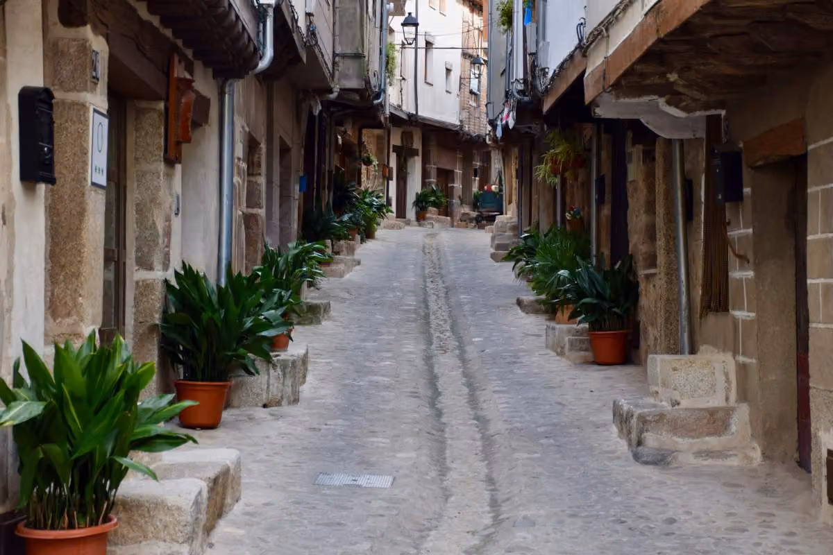 Calle de San Martín de Trevejo con casas de piedra, madera y un regato