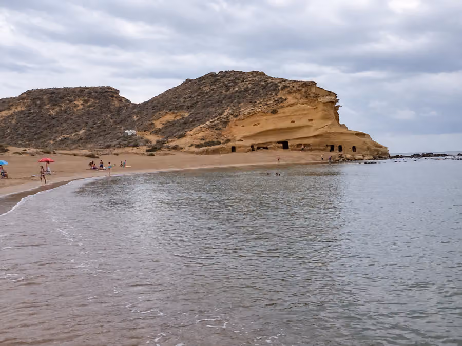 Cala de los Cocedores con acantilados de arenisca y huecos excavados junto a la playa